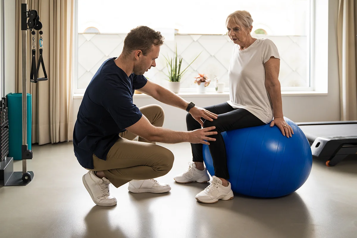 physical therapist assisting senior woman